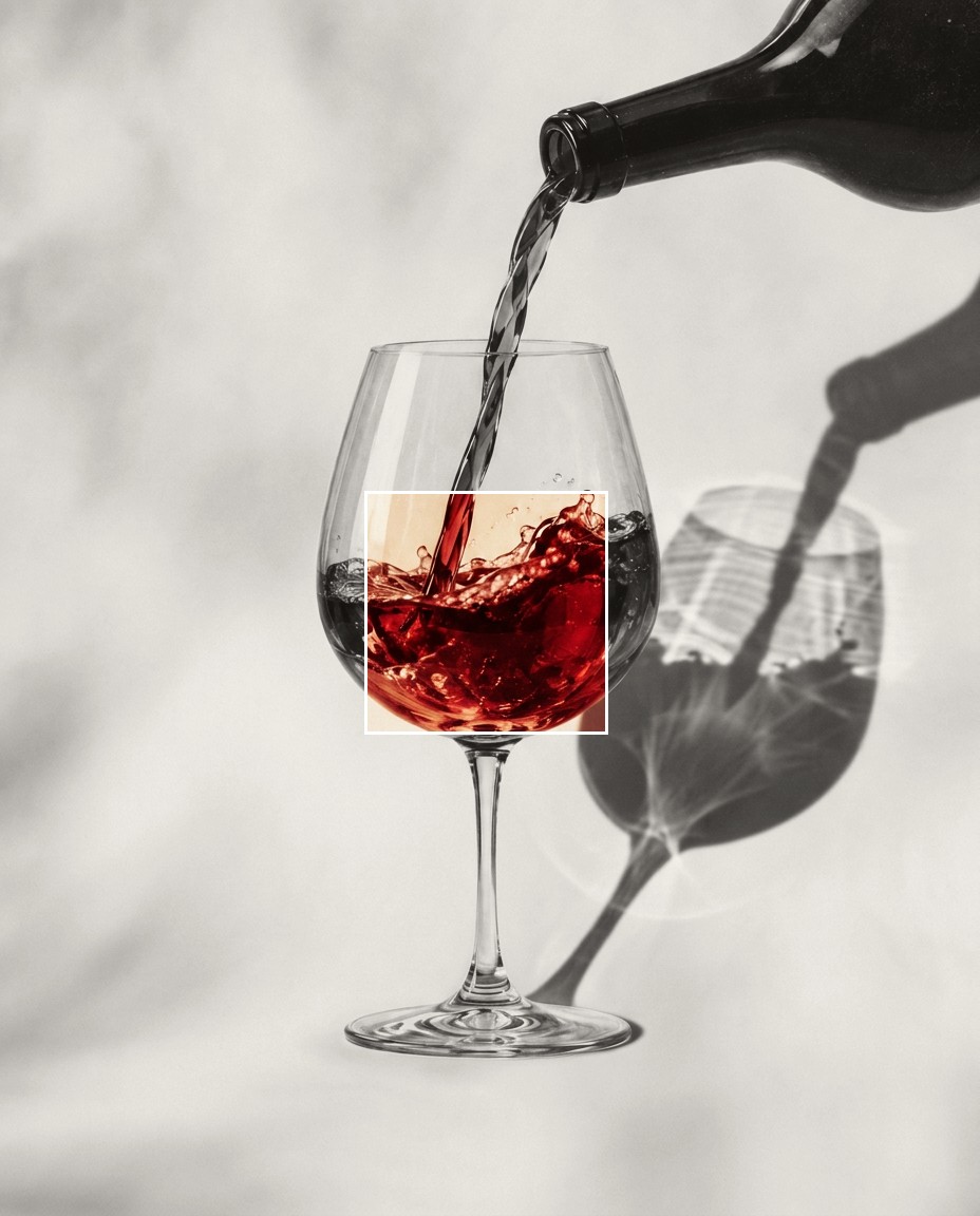 Conceptual editorial image: a glass of red wine beside a bottle